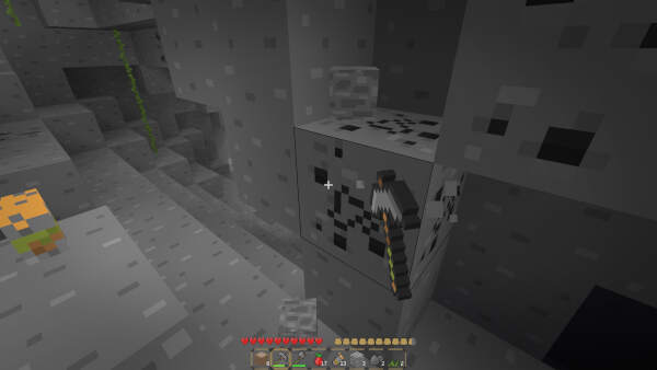 The player is mining coal ore in a cave.